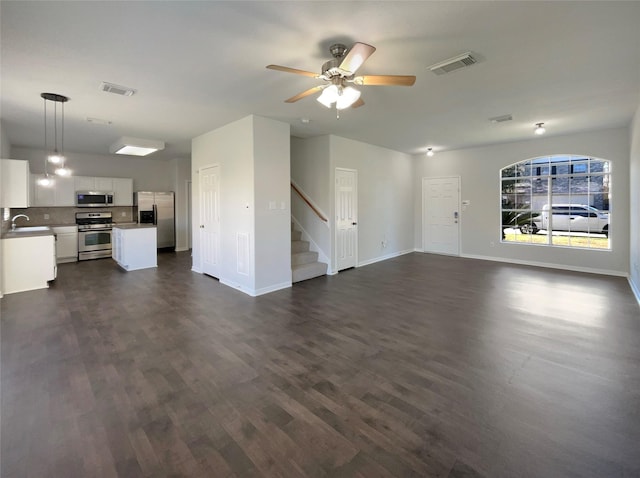 unfurnished living room with ceiling fan, dark hardwood / wood-style flooring, and sink