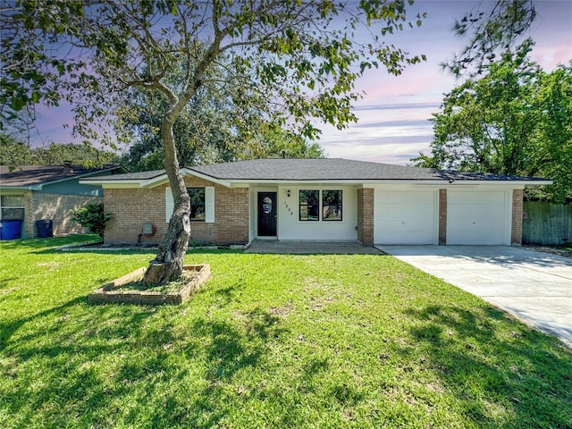 ranch-style home featuring a lawn and a garage