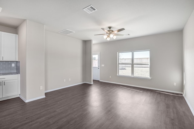 unfurnished living room with dark hardwood / wood-style flooring and ceiling fan