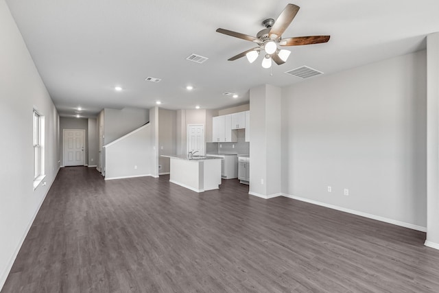 unfurnished living room featuring dark hardwood / wood-style floors and ceiling fan