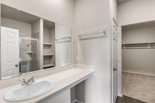 bathroom featuring vanity, hardwood / wood-style flooring, and a shower with shower door