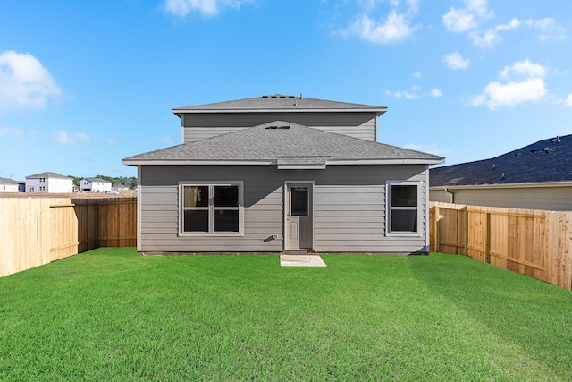 rear view of property featuring a yard