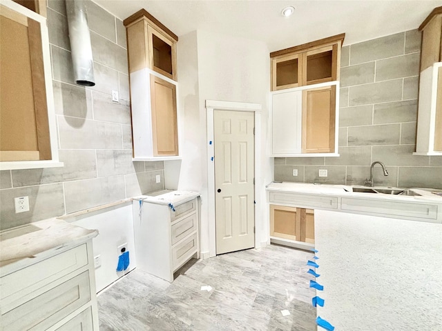 kitchen featuring decorative backsplash, light brown cabinets, and sink