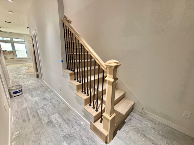 staircase with hardwood / wood-style flooring and ceiling fan