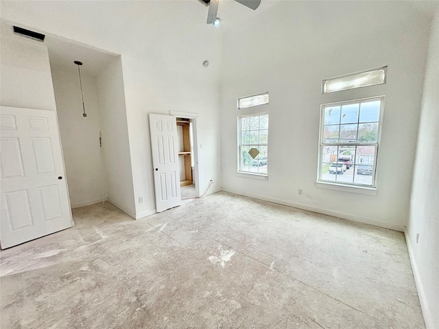 unfurnished bedroom with a towering ceiling and ceiling fan