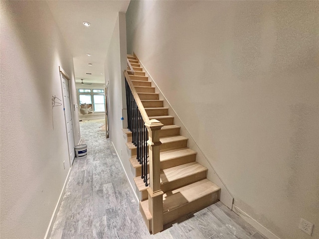 stairway featuring hardwood / wood-style flooring and ceiling fan