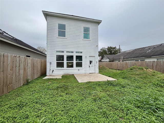 rear view of house featuring a patio and a lawn