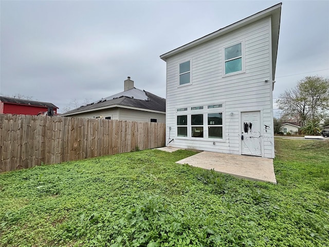 back of house with a patio area and a lawn