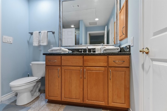 bathroom with toilet, tile patterned floors, and vanity