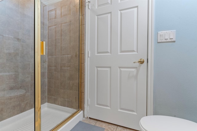 bathroom featuring walk in shower, tile patterned flooring, and toilet