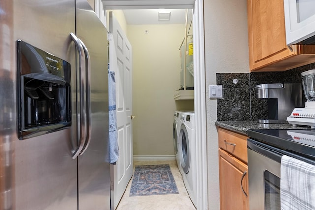 laundry room featuring separate washer and dryer and light tile patterned floors