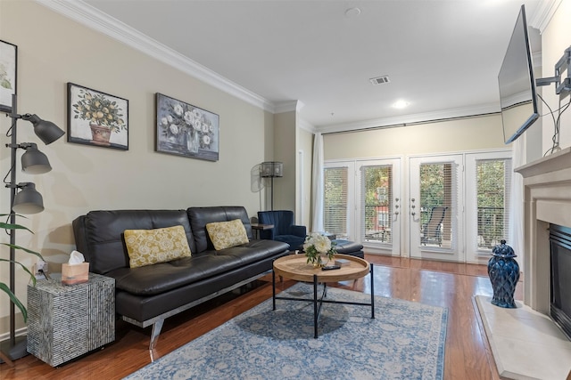 living room with a fireplace, crown molding, and wood-type flooring