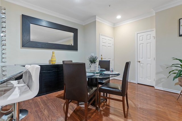 dining room with ornamental molding and wood-type flooring