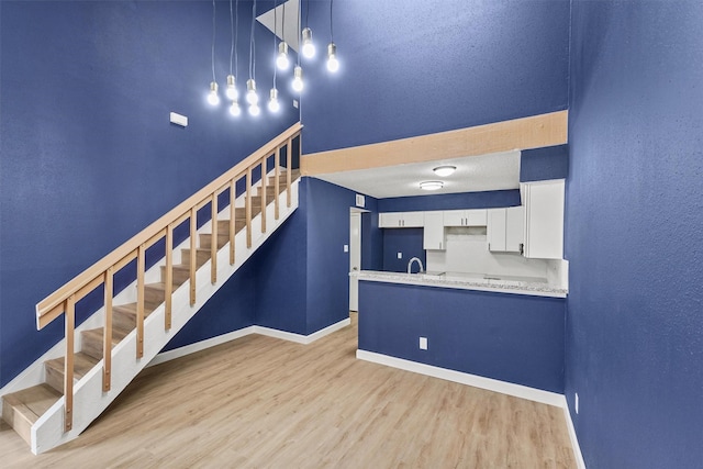 staircase featuring hardwood / wood-style floors, sink, and a textured ceiling