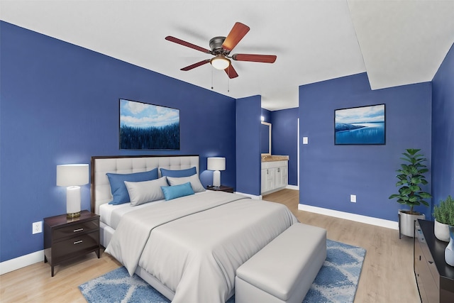 bedroom with ensuite bathroom, light hardwood / wood-style flooring, and ceiling fan