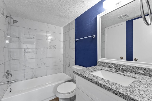 full bathroom with vanity, tiled shower / bath combo, a textured ceiling, and toilet