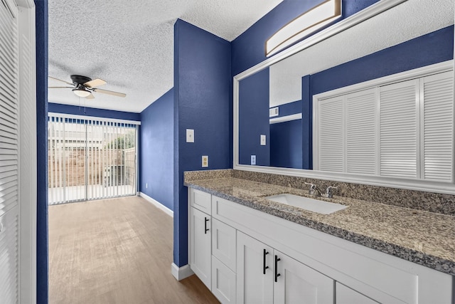 bathroom featuring hardwood / wood-style floors, ceiling fan, a textured ceiling, and vanity