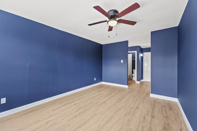 spare room with ceiling fan, light wood-type flooring, and a textured ceiling