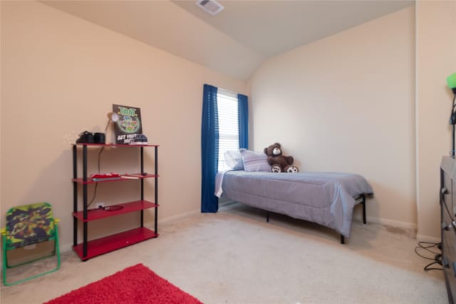 bedroom with light colored carpet and lofted ceiling