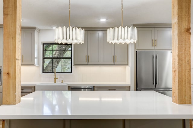 kitchen with stainless steel appliances, hanging light fixtures, gray cabinetry, and sink