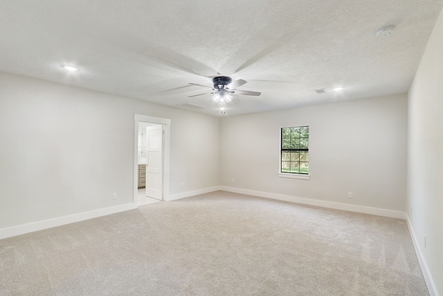 empty room featuring light carpet, ceiling fan, and a textured ceiling