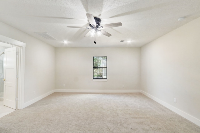 carpeted empty room featuring ceiling fan and a textured ceiling