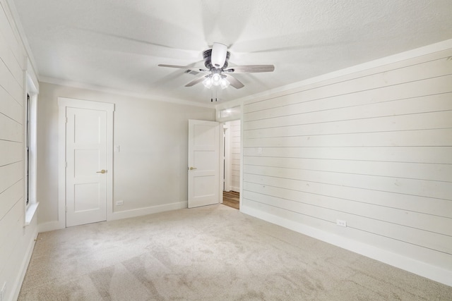 spare room featuring ceiling fan, crown molding, light colored carpet, and a textured ceiling