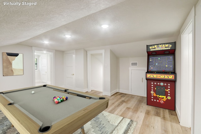 rec room featuring light hardwood / wood-style floors, a textured ceiling, billiards, and vaulted ceiling