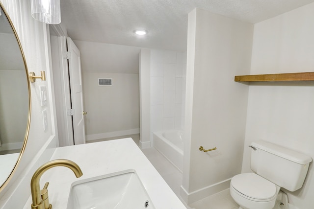 bathroom with a textured ceiling, vanity, and toilet