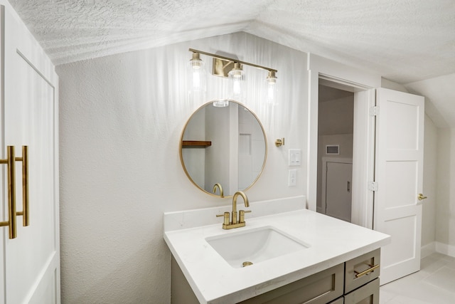 bathroom featuring vanity, lofted ceiling, and a textured ceiling