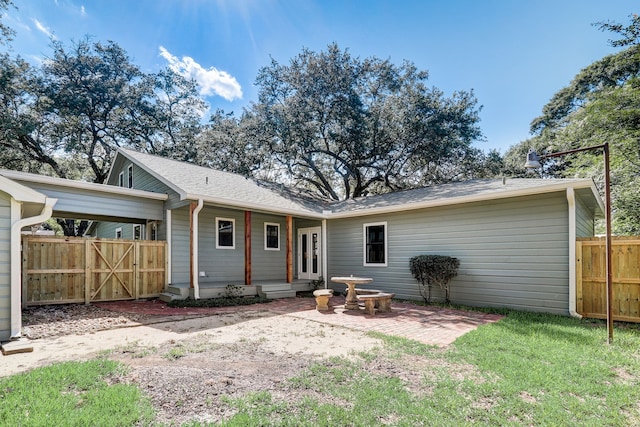 rear view of property with a yard and a patio area