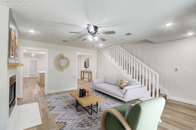 living room featuring hardwood / wood-style floors and ceiling fan