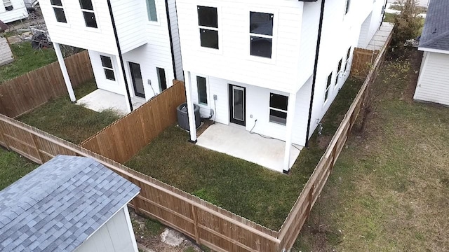 rear view of house featuring a yard, cooling unit, and a patio