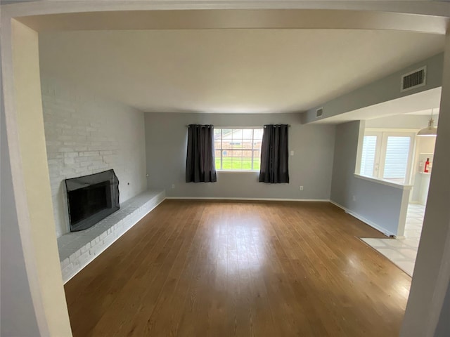 unfurnished living room with a fireplace and hardwood / wood-style flooring