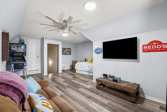 living room featuring ceiling fan, baseboards, and wood finished floors