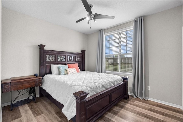 bedroom featuring a ceiling fan, baseboards, and wood finished floors