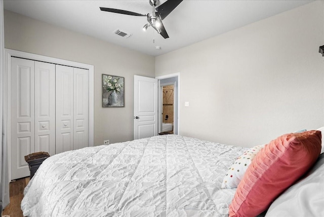 bedroom featuring ceiling fan, visible vents, a closet, and wood finished floors