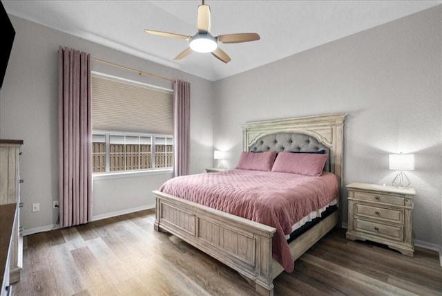 bedroom with ceiling fan, dark wood-style flooring, and baseboards