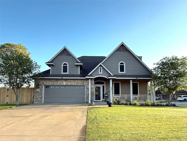 view of front of home featuring a front yard, a porch, an attached garage, fence, and driveway