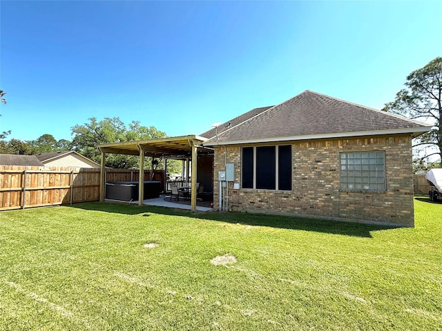 rear view of property with a lawn, a fenced backyard, a patio, brick siding, and roof with shingles