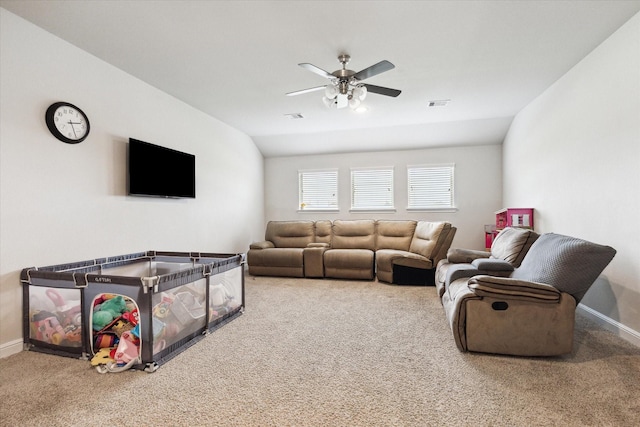 carpeted living room with ceiling fan and vaulted ceiling