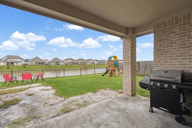 view of patio featuring area for grilling, a water view, and a playground