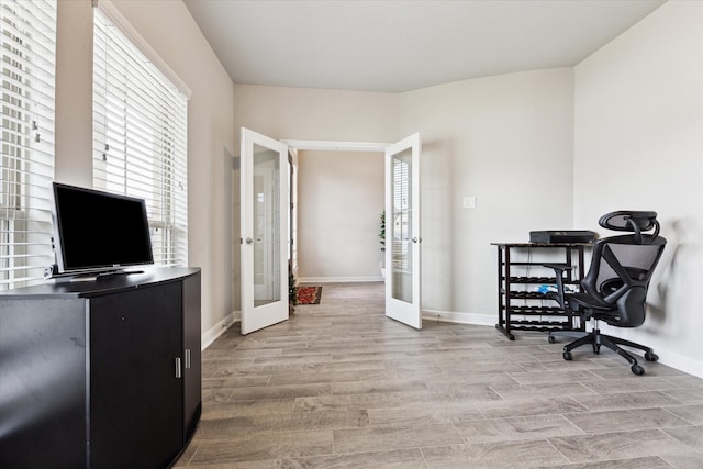 home office with french doors and light hardwood / wood-style flooring