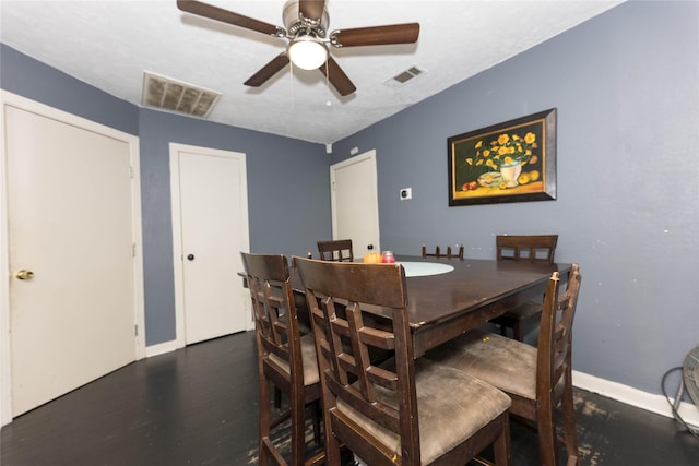 dining room with ceiling fan, dark wood-type flooring, and a textured ceiling