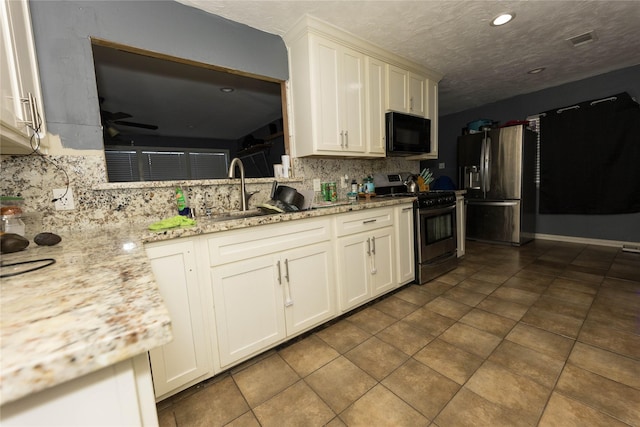 kitchen featuring ceiling fan, sink, stainless steel appliances, light stone counters, and tile patterned floors