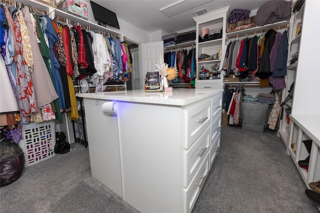 walk in closet with dark colored carpet