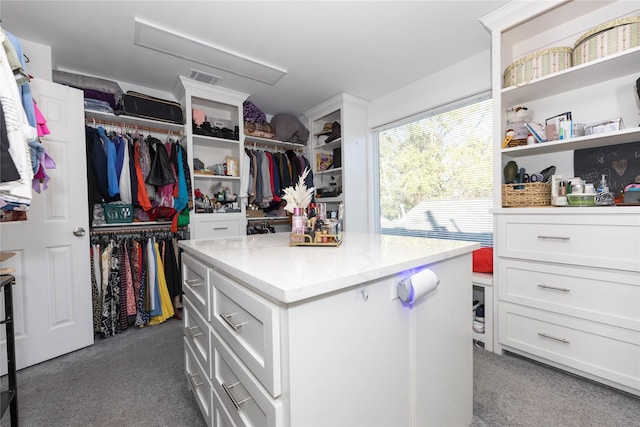 walk in closet featuring dark carpet