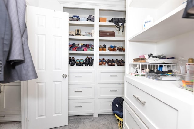 walk in closet featuring light colored carpet