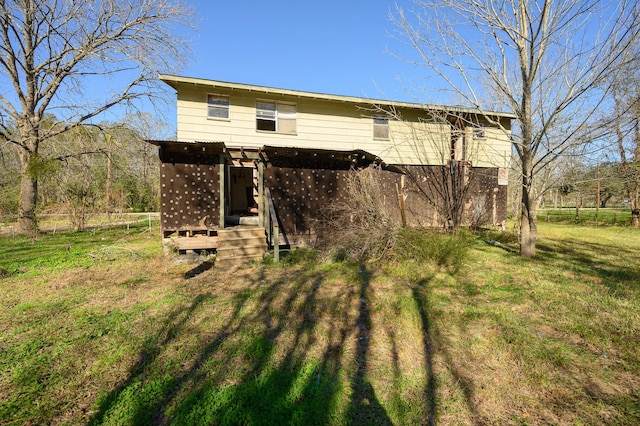 rear view of house featuring a lawn