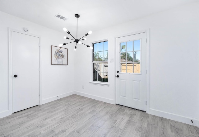 interior space with light hardwood / wood-style flooring and an inviting chandelier